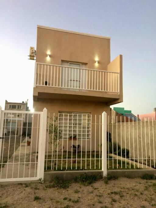 a house with a white fence in front of it at Moana II in Las Grutas