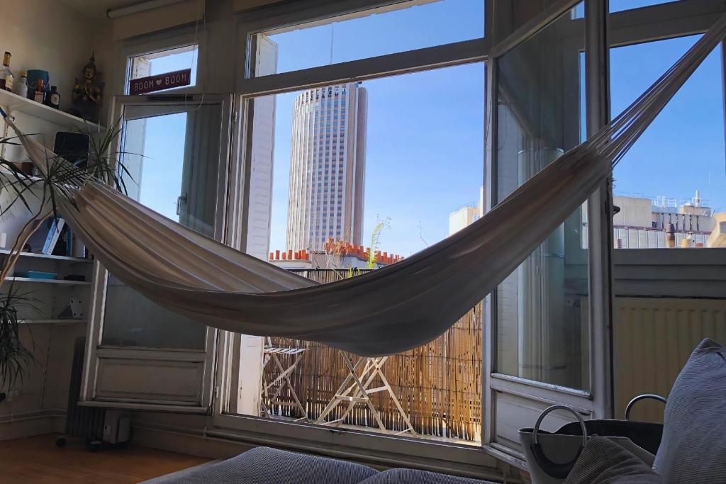 - un hamac dans une chambre avec une grande fenêtre dans l'établissement 2 pièces proche Palais des Congrès, à Paris
