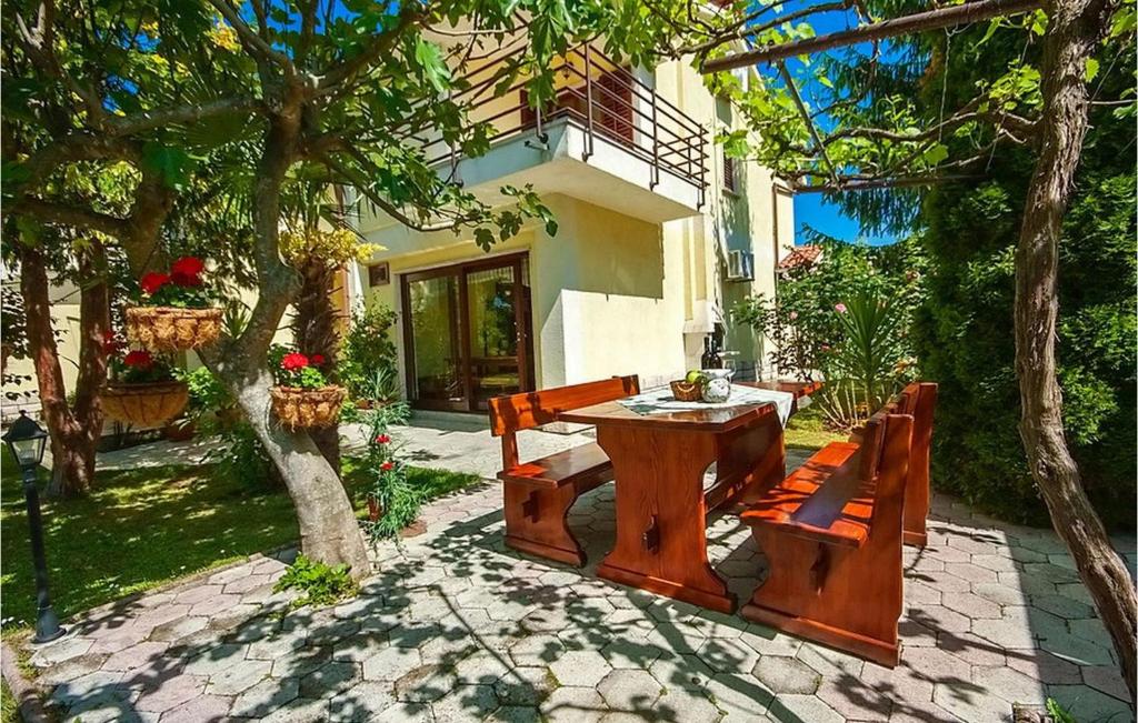 a patio with a table and benches and a building at Adorata 1 in Labin