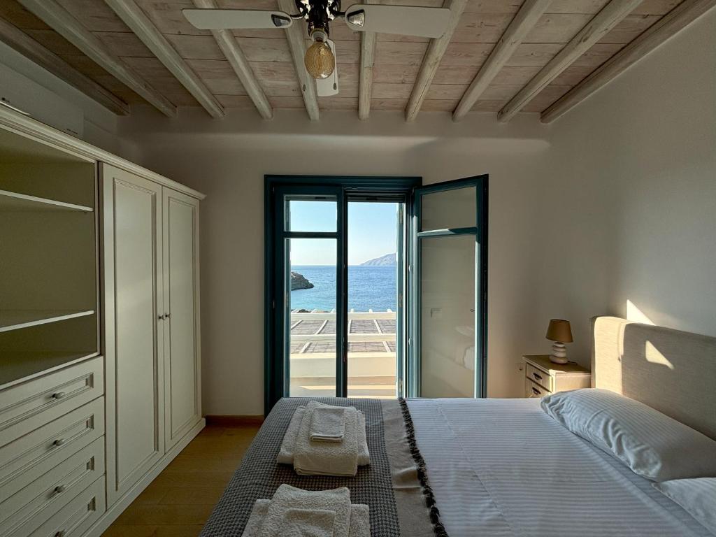 a bedroom with a bed and a view of the ocean at Almyra Yellow Villa in Kithnos