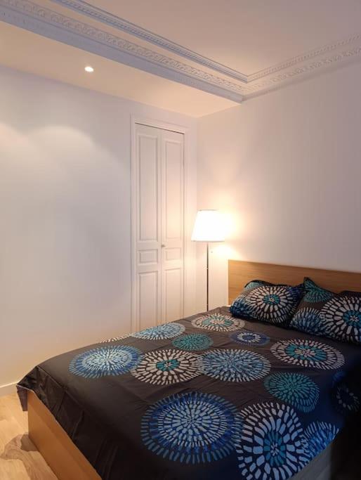 une chambre avec un lit avec des oreillers bleus et blancs dans l'établissement Flat 31m2 near Pompidou Center, Marais, les Halles, mobility lease only, à Paris