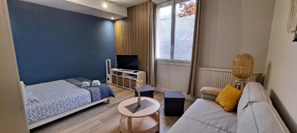 - un petit salon avec un lit et un canapé dans l'établissement Le Nid Secret 5 Minutes a pied de la plage avec place Parking privée, au Havre