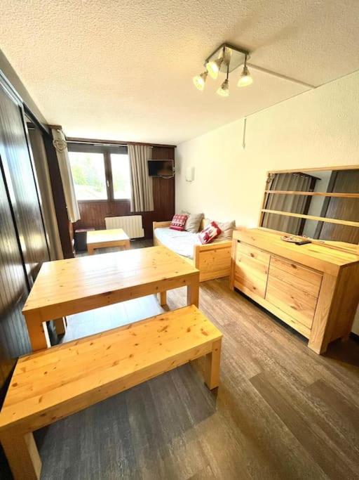un salon avec une table en bois et un canapé dans l'établissement Serre Chevalier Chantemerle Vue Montagne, à Saint-Chaffrey