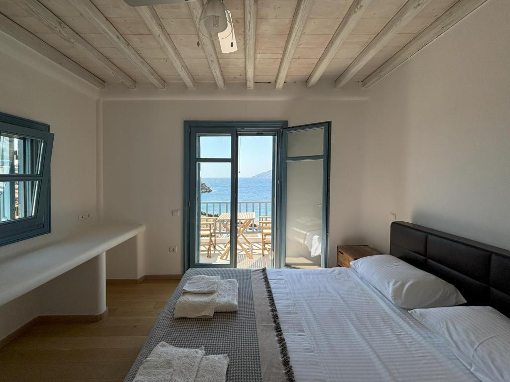 a bedroom with a bed and a view of the ocean at Almyra Red Villa in Kithnos