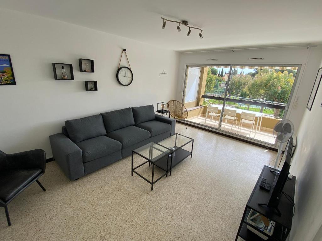 un salon avec un canapé et une table dans l'établissement T3 vue mer piscine proche plage, à Bormes-les-Mimosas