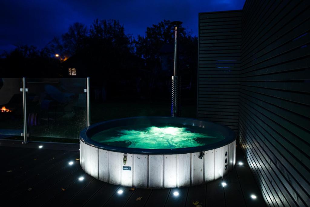 a jacuzzi tub on a balcony at night at Luxury Guest House - Hot Tub & Sauna in Valmiera