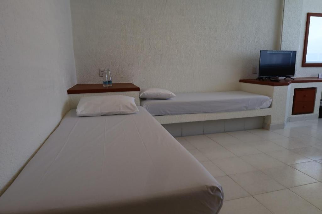 Postel nebo postele na pokoji v ubytování Hotel Aristos Acapulco