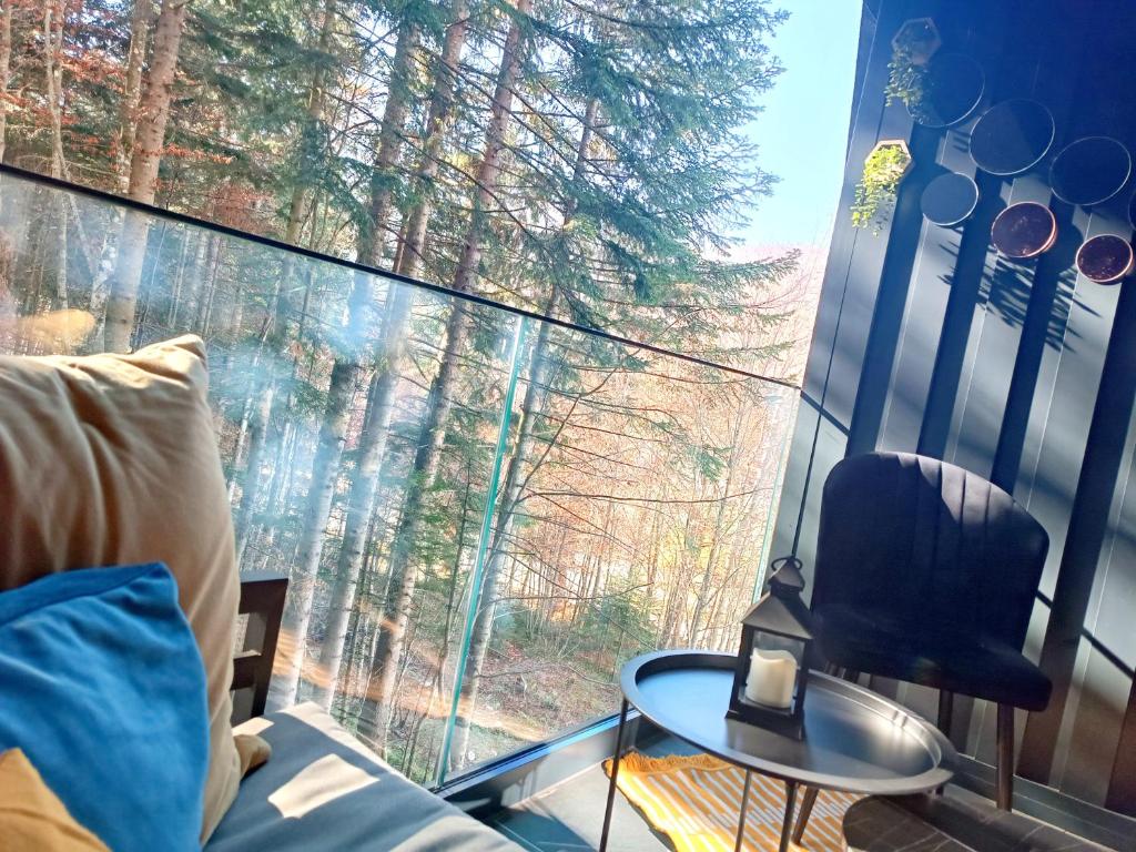 Zimmer mit einem großen Fenster mit einem Sofa und einem Tisch in der Unterkunft Oaza1 in Trnovo