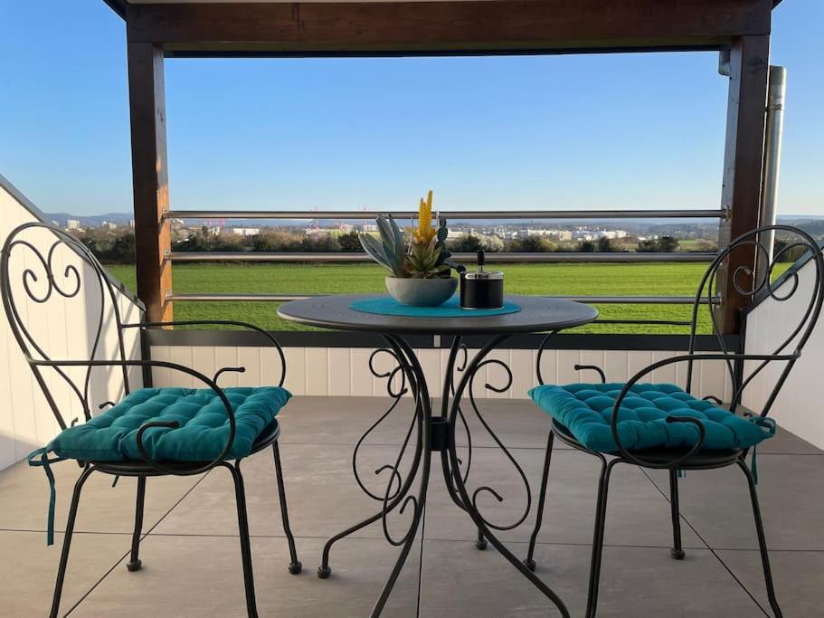 une table et des chaises sur un porche avec vue dans l'établissement Loft Bellevue, à Saint-Louis