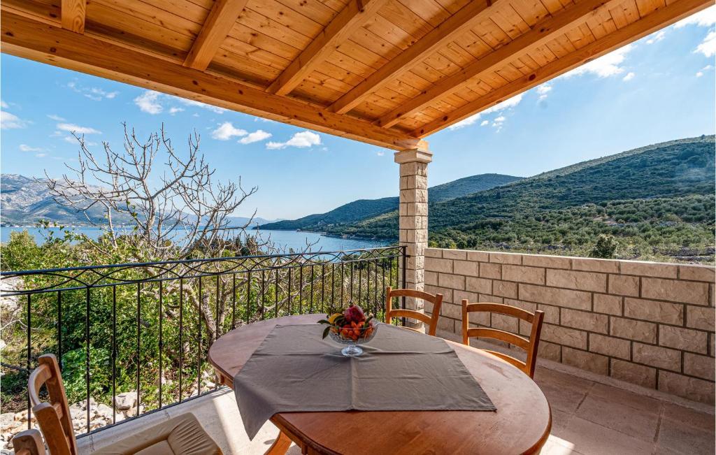 une table sur un balcon avec vue sur l'eau dans l'établissement 1 Bedroom Cozy Apartment In Kneze, à Pupnat