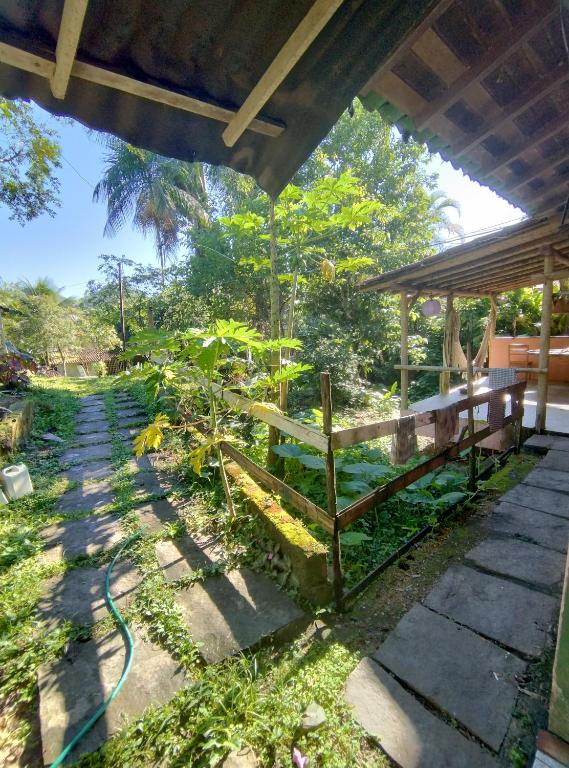 een tuin met een bank en een paviljoen bij Sitio Flor do Coriscão Paraty in Paraty