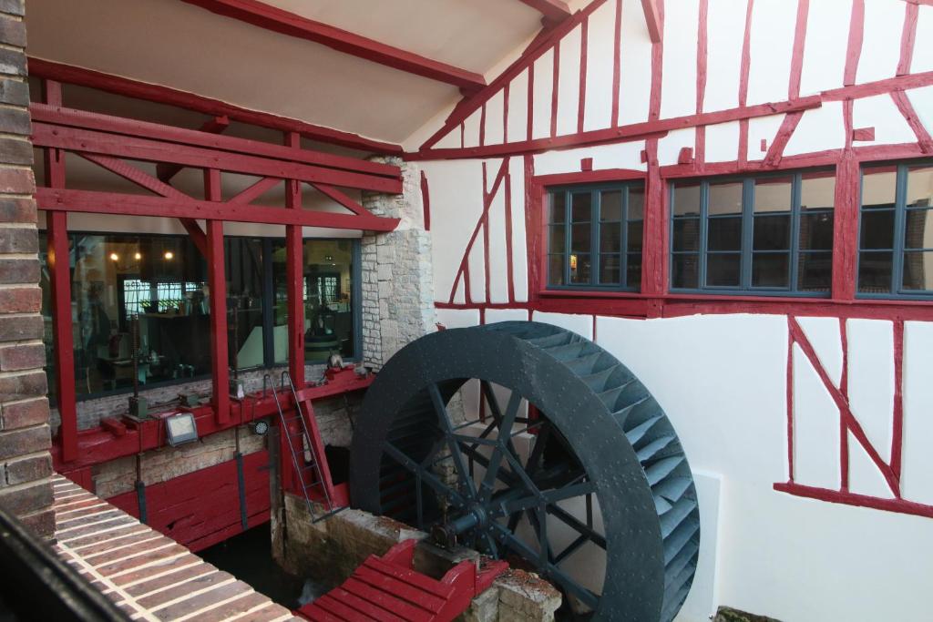 a room with a large wheel in a building at Le Moulin Du Landion Hôtel et Spa in Dolancourt