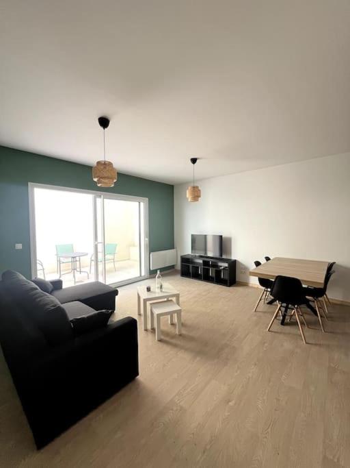 un salon avec un canapé et une table dans l'établissement Le spacieux et sa terrasse, à Vichy