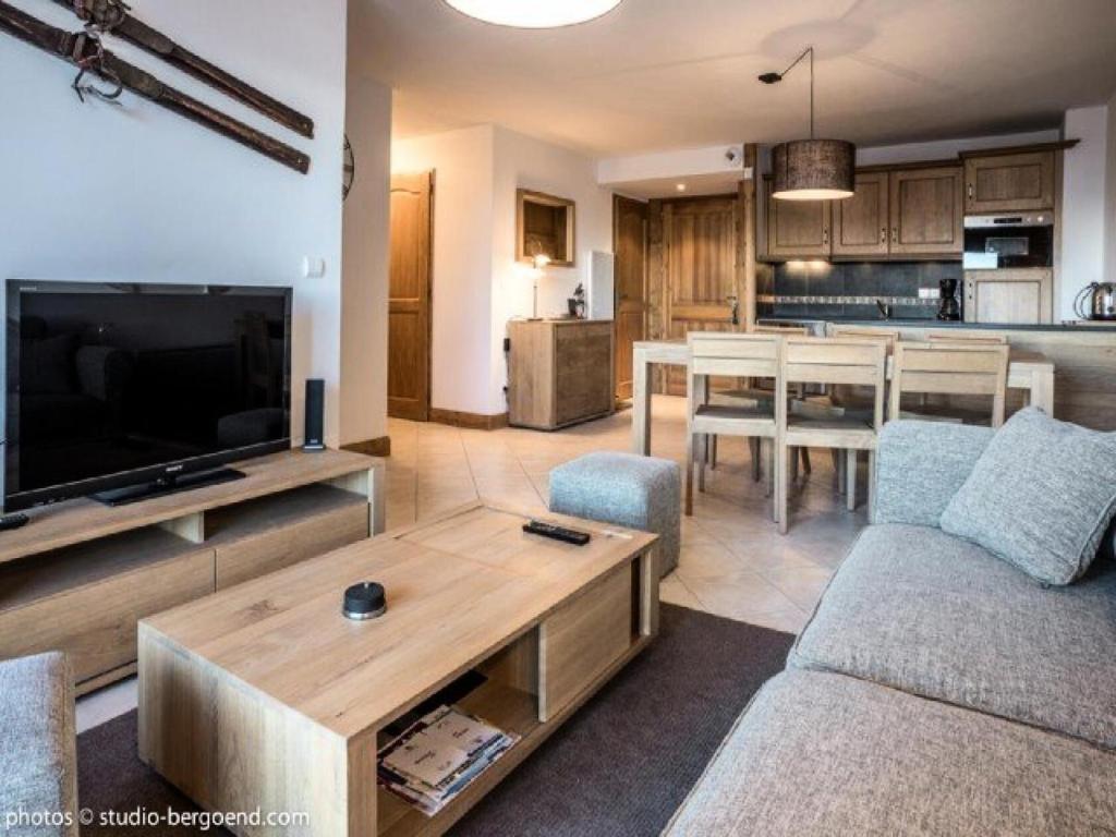 un salon avec un canapé, une télévision et une table dans l'établissement Résidence Iseran - ISERAN 19 MAE-9961, à Arc 1800