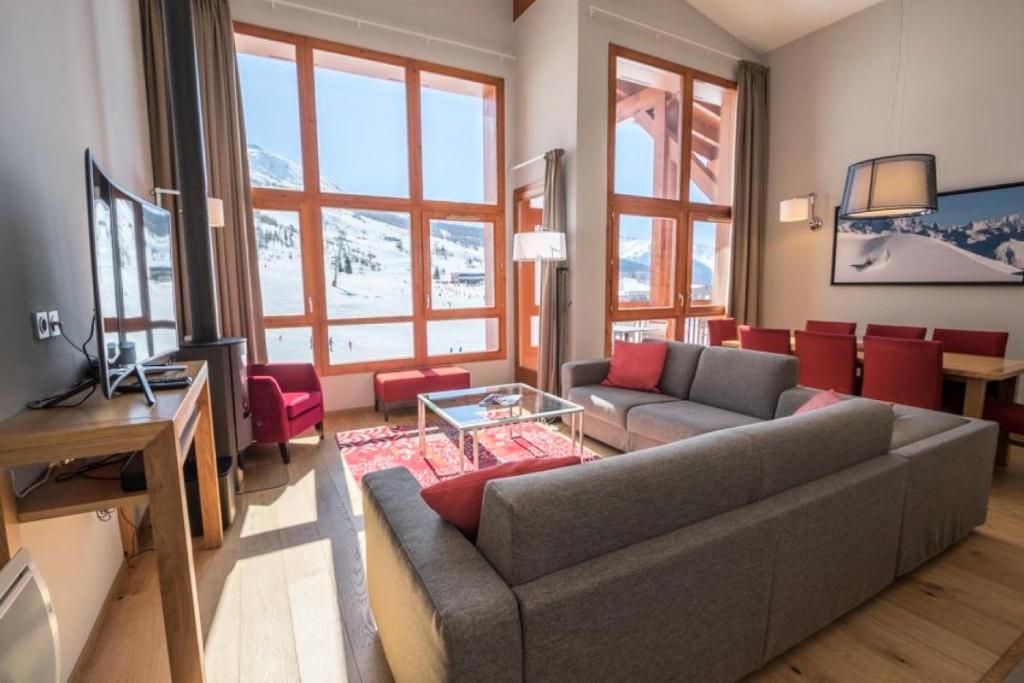 un salon avec un canapé et une télévision dans l'établissement Résidence Les Monarques - MONARQUES 501 MAE-0011, à Arc 1800