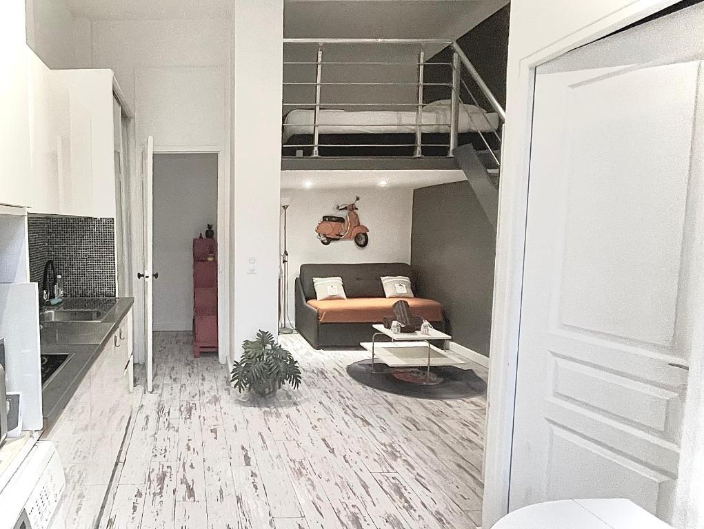 - un salon avec un canapé et un lit en mezzanine dans l'établissement Malyandco, à Nice