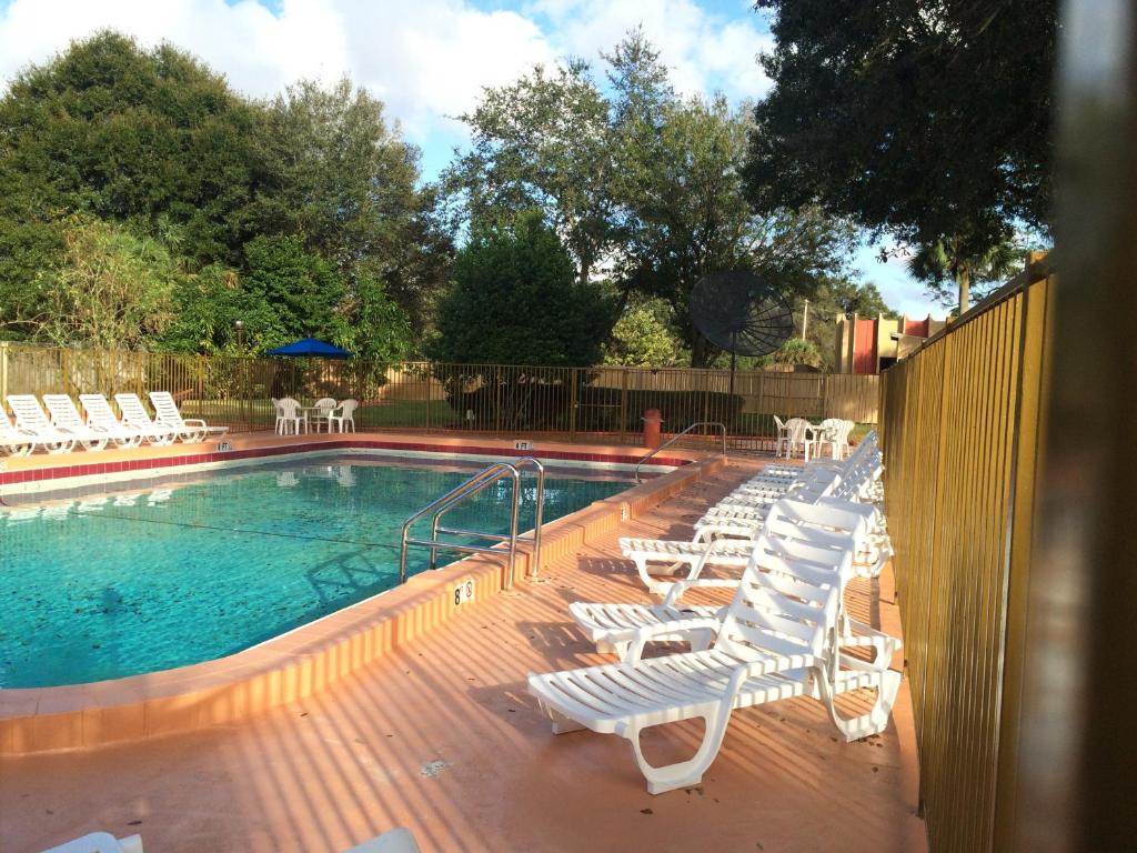 a deck with lounge chairs and a swimming pool at Valuelodge Busch Gardens - Tampa in Tampa