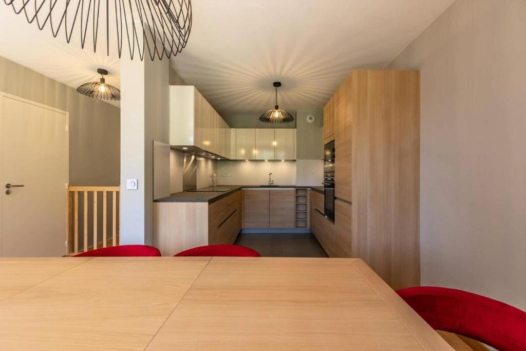 une salle à manger et une cuisine avec une table et des chaises rouges dans l'établissement Résidence Les Monarques - MONARQUES 905 MAE-0151, à Arc 1800
