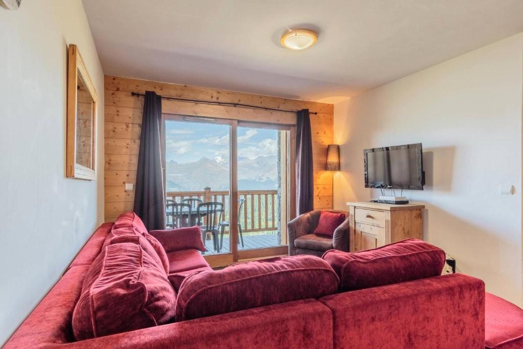 un salon avec un canapé rouge et une télévision dans l'établissement Résidence Iseran - ISERAN 7 MAE-0201, à Arc 1800