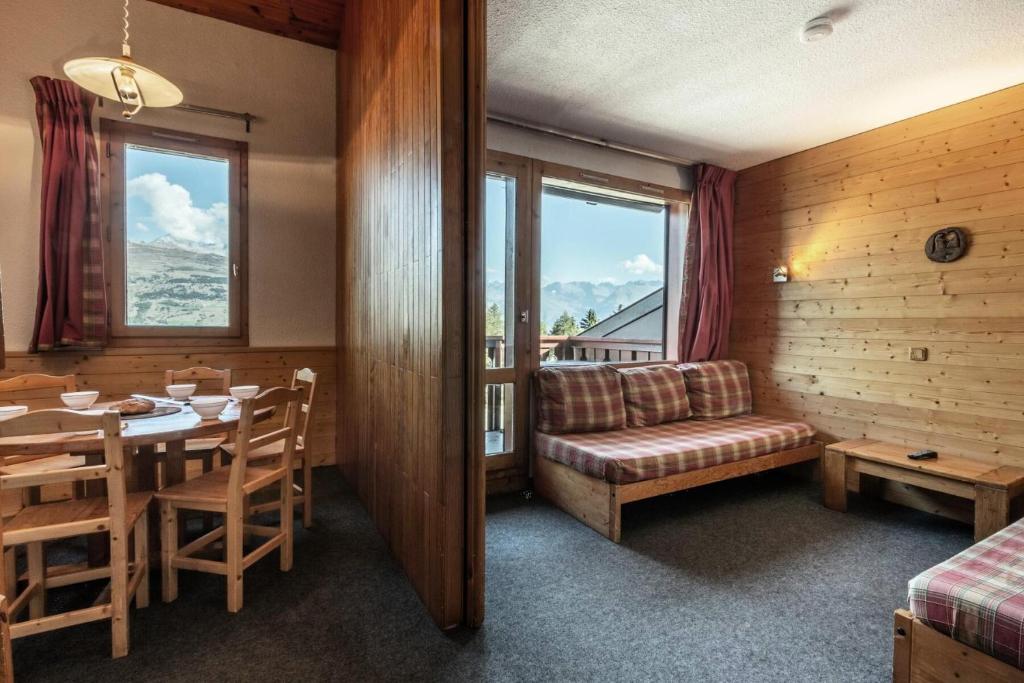 une salle à manger avec une table et un canapé dans l'établissement Résidence Le Zig Zag - ZIG ZAG 39 MAE-0331, à La Plagne Tarentaise