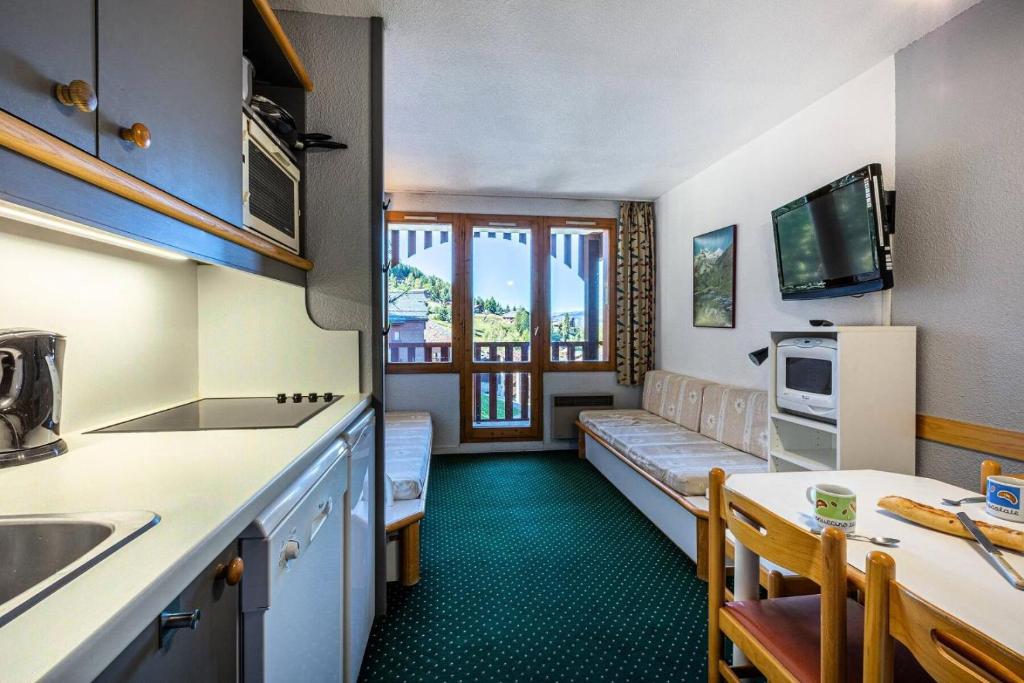 - une cuisine avec un canapé et une table dans une chambre dans l'établissement Résidence Le De 4 - Appartement 2 pièces pour 5 personnes de 26m² MAE-0361, à La Plagne Tarentaise