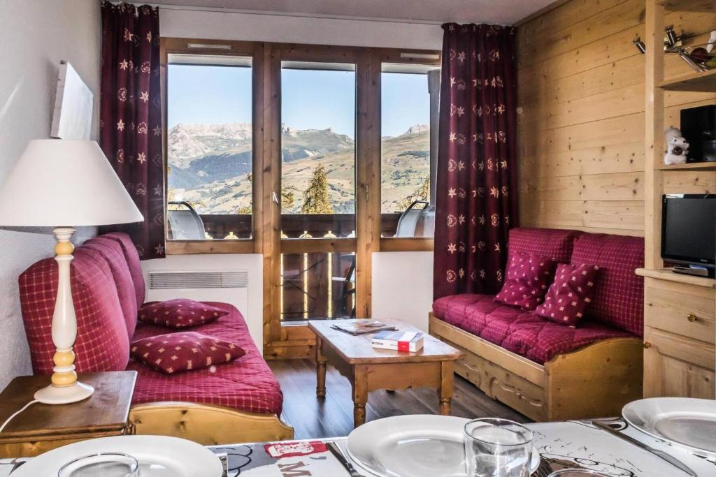 ein Wohnzimmer mit Sofa und Tisch in der Unterkunft Résidence Le Sextant - SEXTANT 110 MAE-0481 in La Plagne Tarentaise