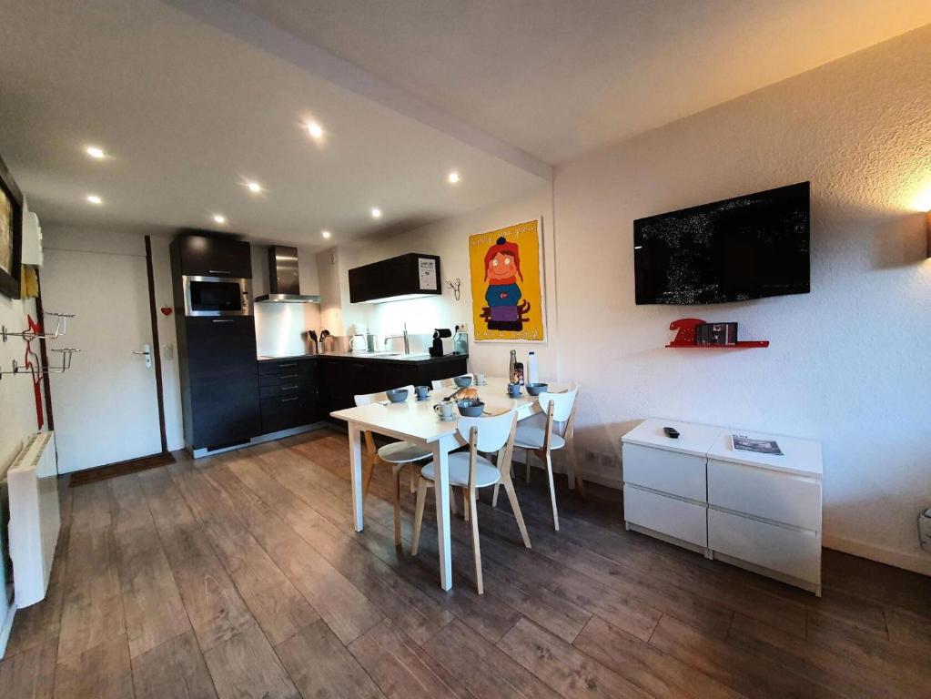 une cuisine avec une table et des chaises dans une pièce dans l'établissement Résidence Le Trompe L'oeil - TROMPE L'OEIL 28 MAE-0491, à La Plagne Tarentaise