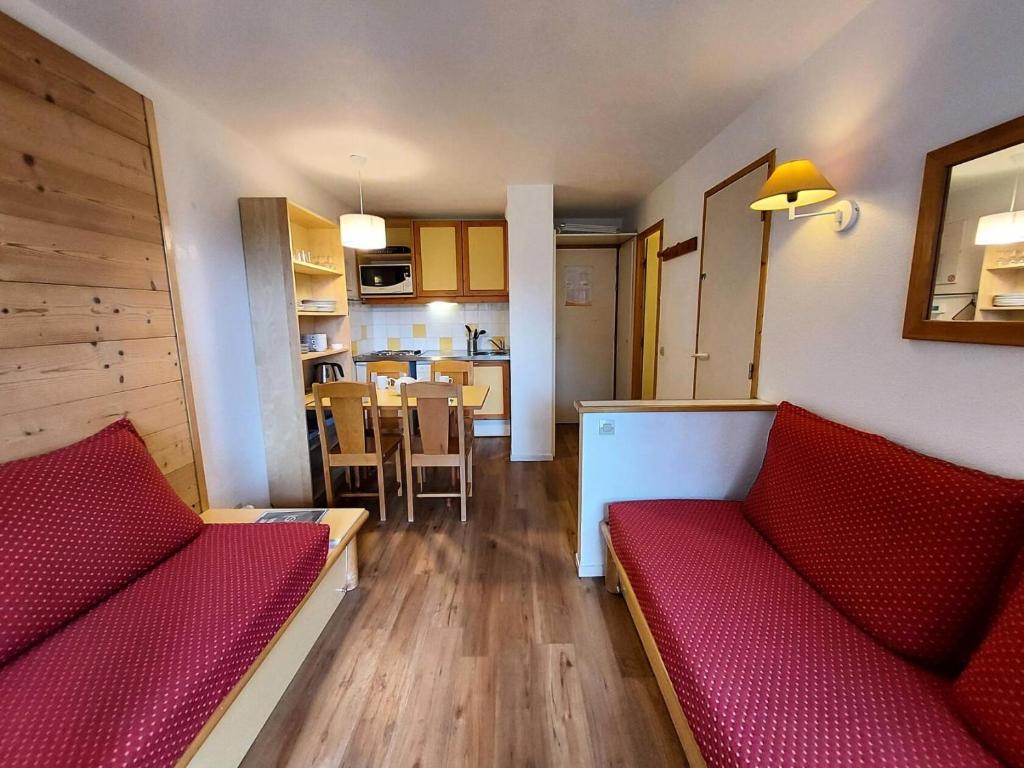 un salon avec deux canapés rouges et une cuisine dans l'établissement Résidence L'epervier - Appartement 2 pièces pour 6 personnes de 47m² MAE-0571, à La Plagne Tarentaise