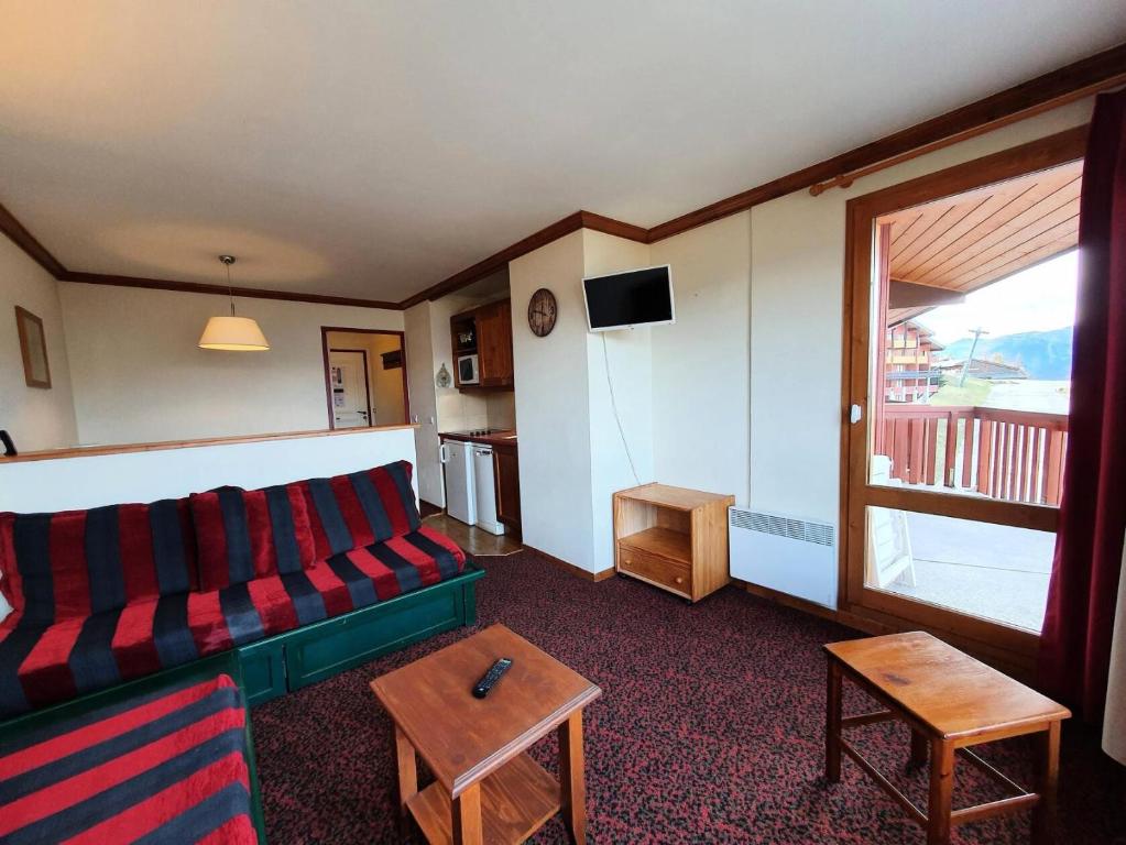 un salon avec un canapé et une fenêtre dans l'établissement Résidence Le Rami - RAMI 401 MAE-0681, à La Plagne Tarentaise