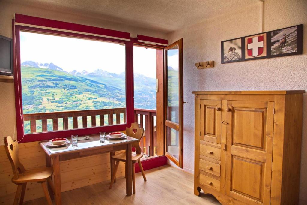 une salle à manger avec une table et une grande fenêtre dans l'établissement Résidence L'equerre - Studio pour 2 personnes de 17m² MAE-0801, à La Plagne Tarentaise