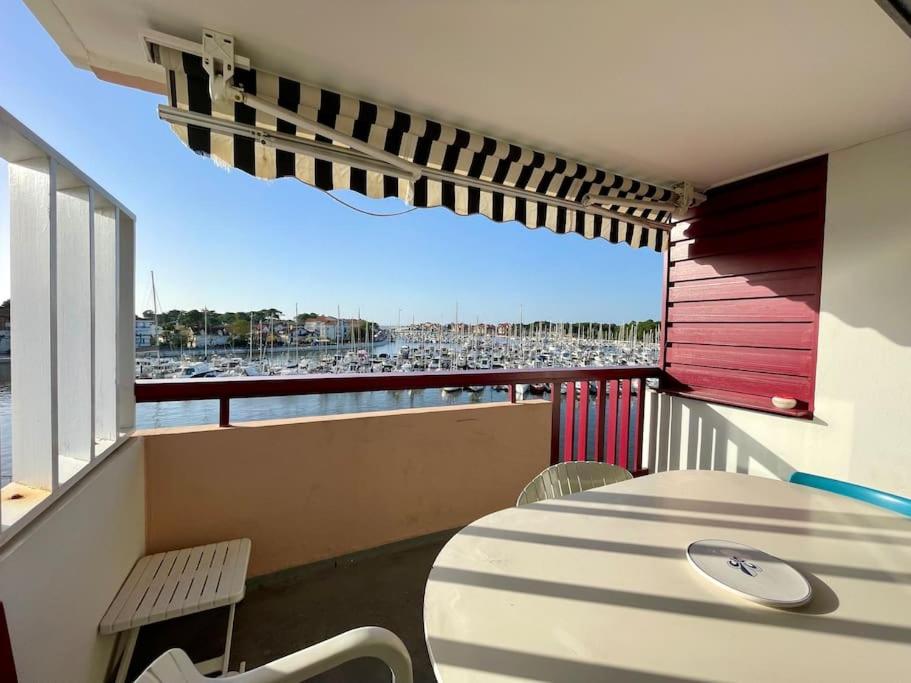 d'un balcon avec une table et une vue sur la plage. dans l'établissement Appartement avec balcon vue sur le port & piscine, à Capbreton
