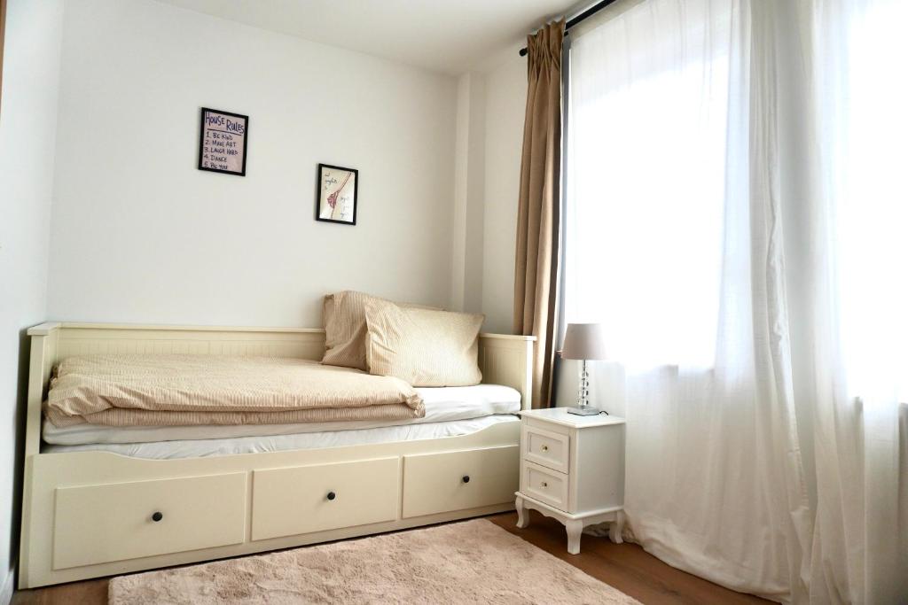 a white bedroom with a bed and a window at Le cozy escape in Herstal