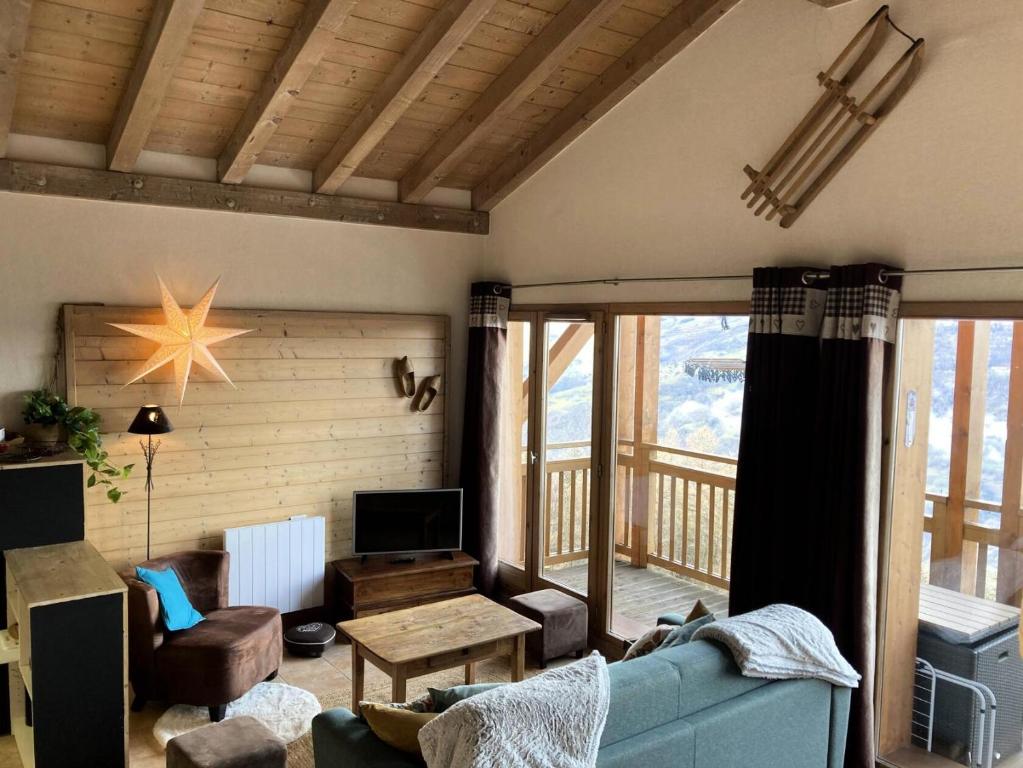 un salon avec un canapé bleu et un balcon dans l'établissement Les Chalets De Wengen - CHALETS DE WENGEN 95 MAE-0861, à La Plagne Tarentaise