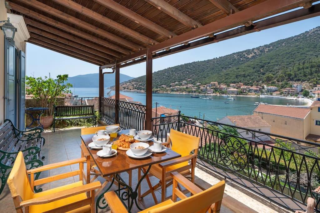 una mesa en un balcón con vistas al agua en Nonna House, en Agia Efimia