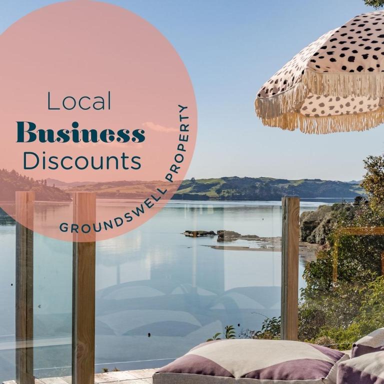 a sign that reads local business discounts and a view of the water at Sunshine Rise, Upstairs Unit, Romantic, Waterfront Retreat in Raglan