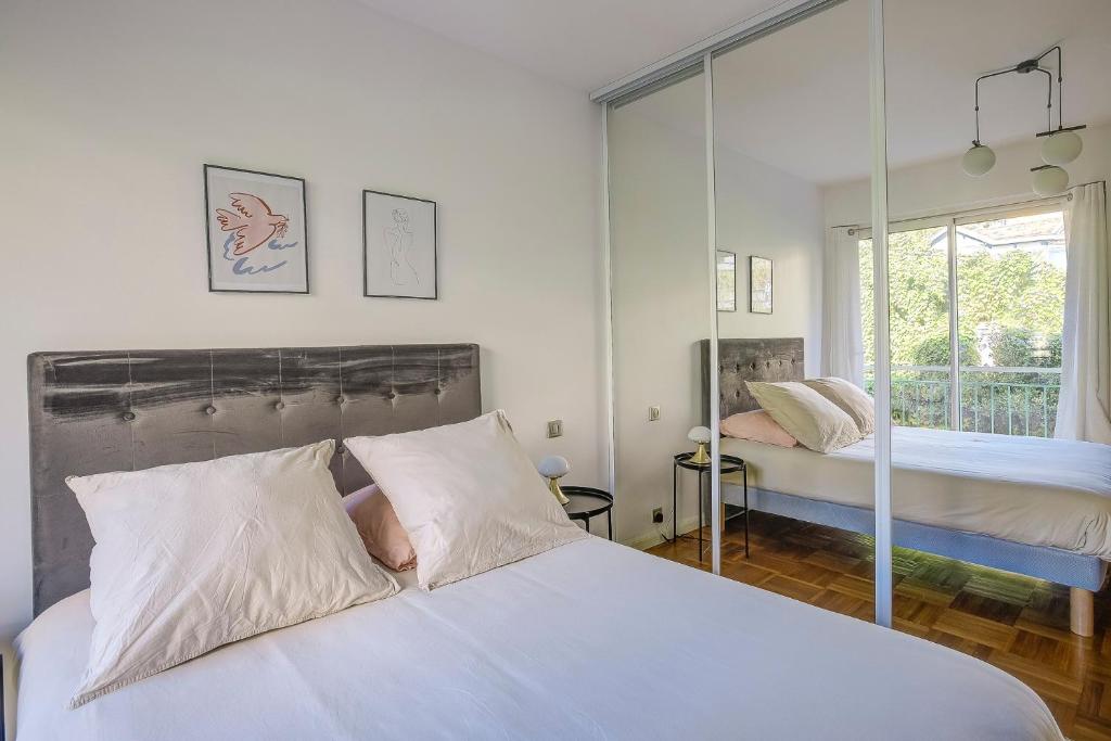 une chambre avec deux lits et une grande fenêtre dans l'établissement Dolce vita, à Nice