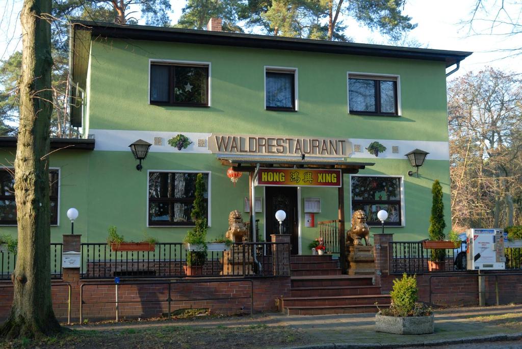 um edifício verde com um sinal que diz preservativo de paredes em Waldrestaurant & Hotel em Rangsdorf