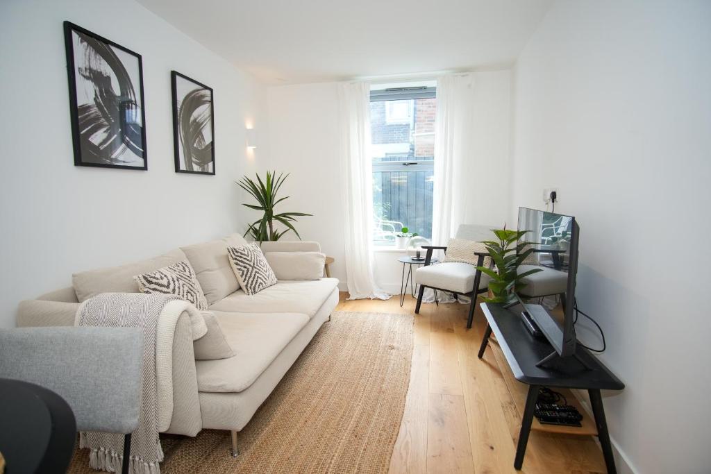 Una sala de estar con un sofá blanco y una mesa. en Eastbourne Central Apartment Short and Long Stay welcome, en Eastbourne