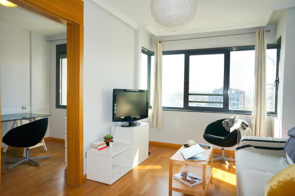 sala de estar con sofá y TV en Apartamentos Madrid Anderson en Madrid