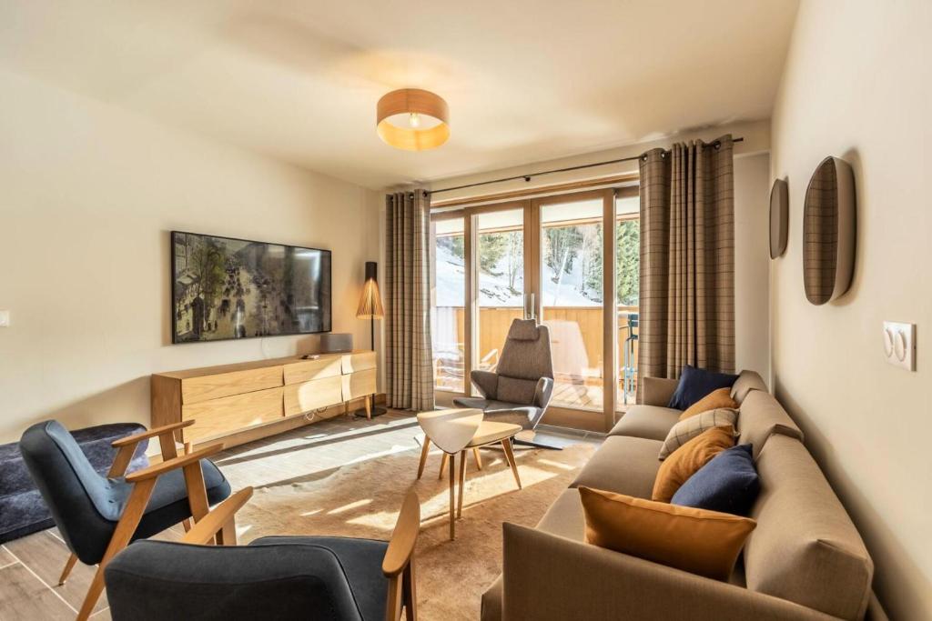un salon avec un canapé et des chaises dans l'établissement Résidence Le Ridge - RIDGE 301 MAE-5081, à Arc 1600
