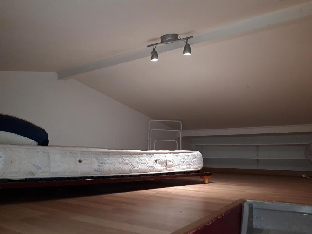 une chambre vide avec un lit dans un grenier dans l'établissement Petit maison avec jardin, à Roquettes