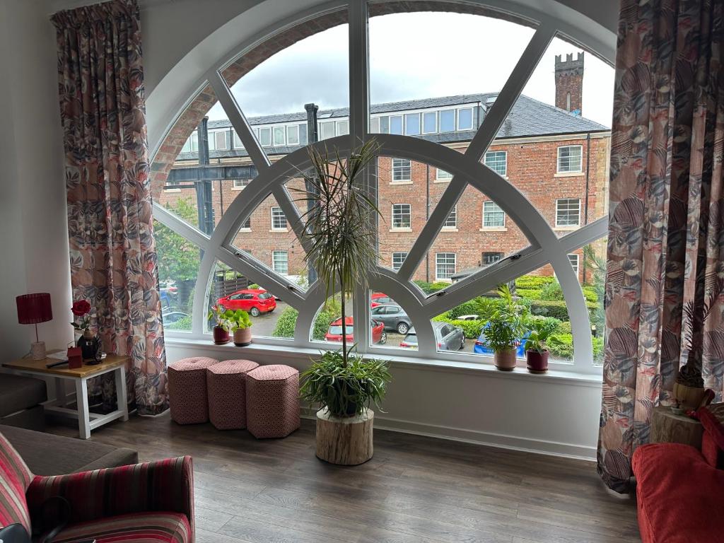une pièce avec une grande fenêtre avec des plantes en pot dans l'établissement Stunning 2 bedroom apartment, à Glasgow