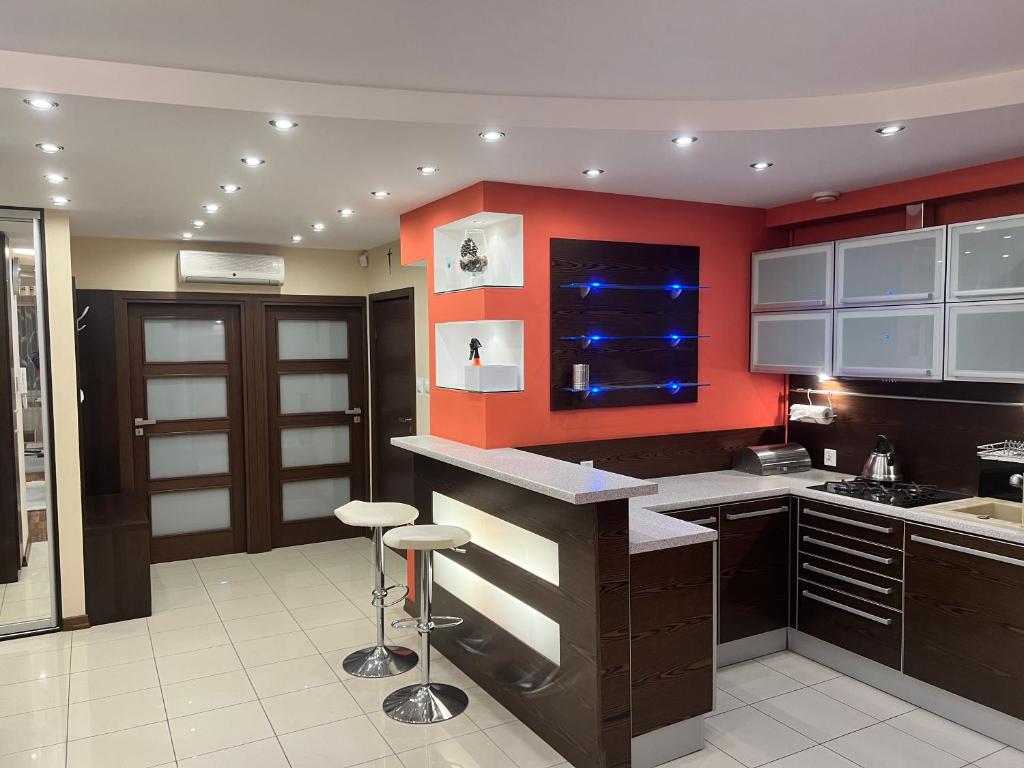a kitchen with red walls and a counter with stools at Apartament Dona, Topazowa 4 in Lublin