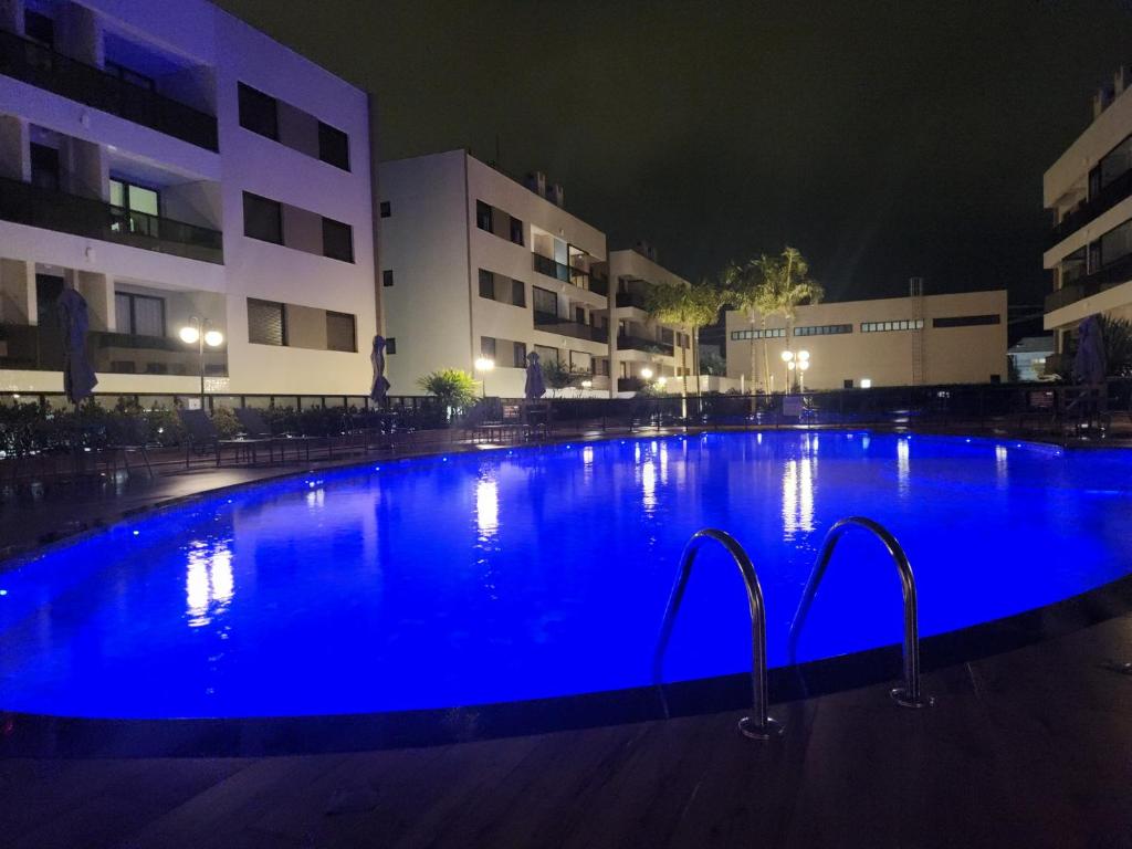 a large swimming pool with blue water at night at Mar de ensueños in Florianópolis