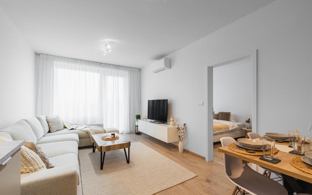 a white living room with a couch and a table at BNB Urban Oasis Bajkalska in Bratislava
