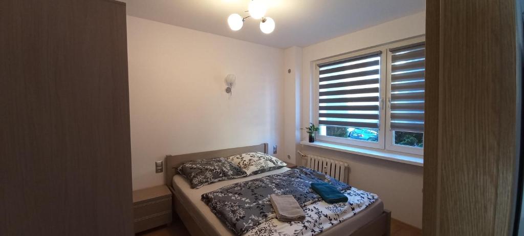una piccola camera da letto con un letto e una finestra di Apartament JUKI, obok Katowice Wynajem na doby, krótkoterminowy, 2 pokoje balkon, 50m2,- po kapitalnym remoncie 2-ga sypialnia jest częścią salonu blisko Centrum Leczenia Oparzeń 2,5 km a Siemianowice Śląskie