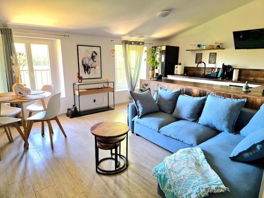 un salon avec un canapé bleu et une table dans l'établissement Appartement T3 campagne, à Forcalqueiret