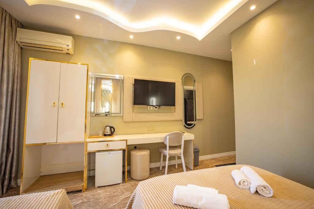 a bedroom with a desk and a tv on the wall at Hotel Flash in Istanbul