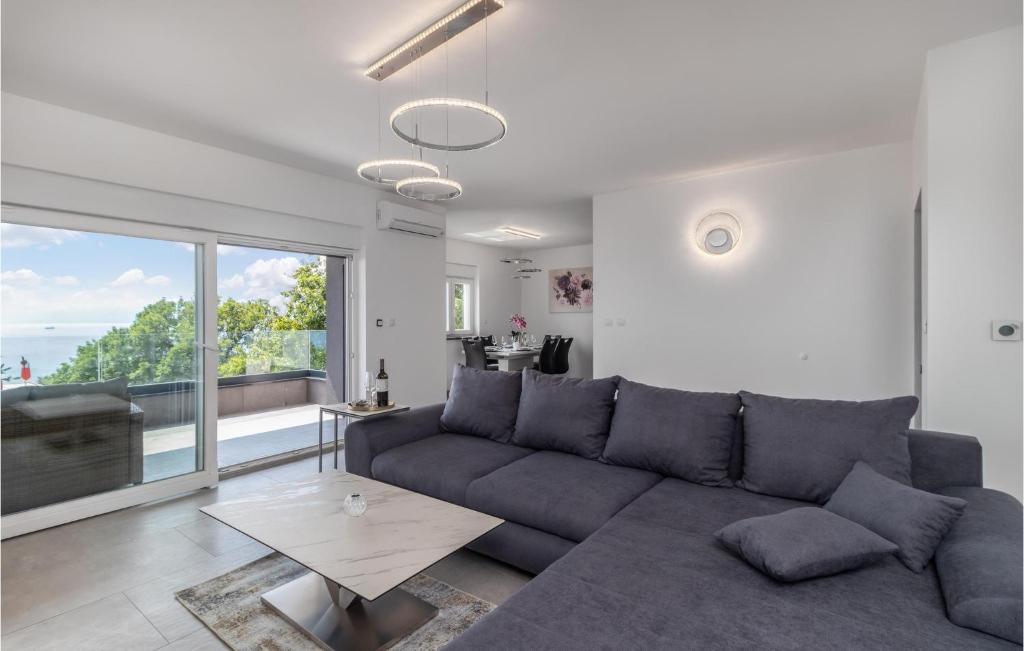 a living room with a couch and a large window at 3 Bedroom Awesome Apartment In Kostrena in Kostrena