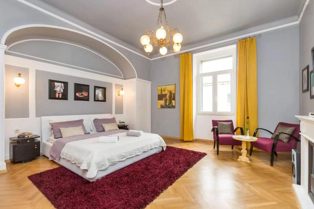 Un dormitorio con una cama grande y una alfombra roja en Riva Waterfront Apartments en Split
